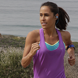 woman wearing sweatproof earbuds while running