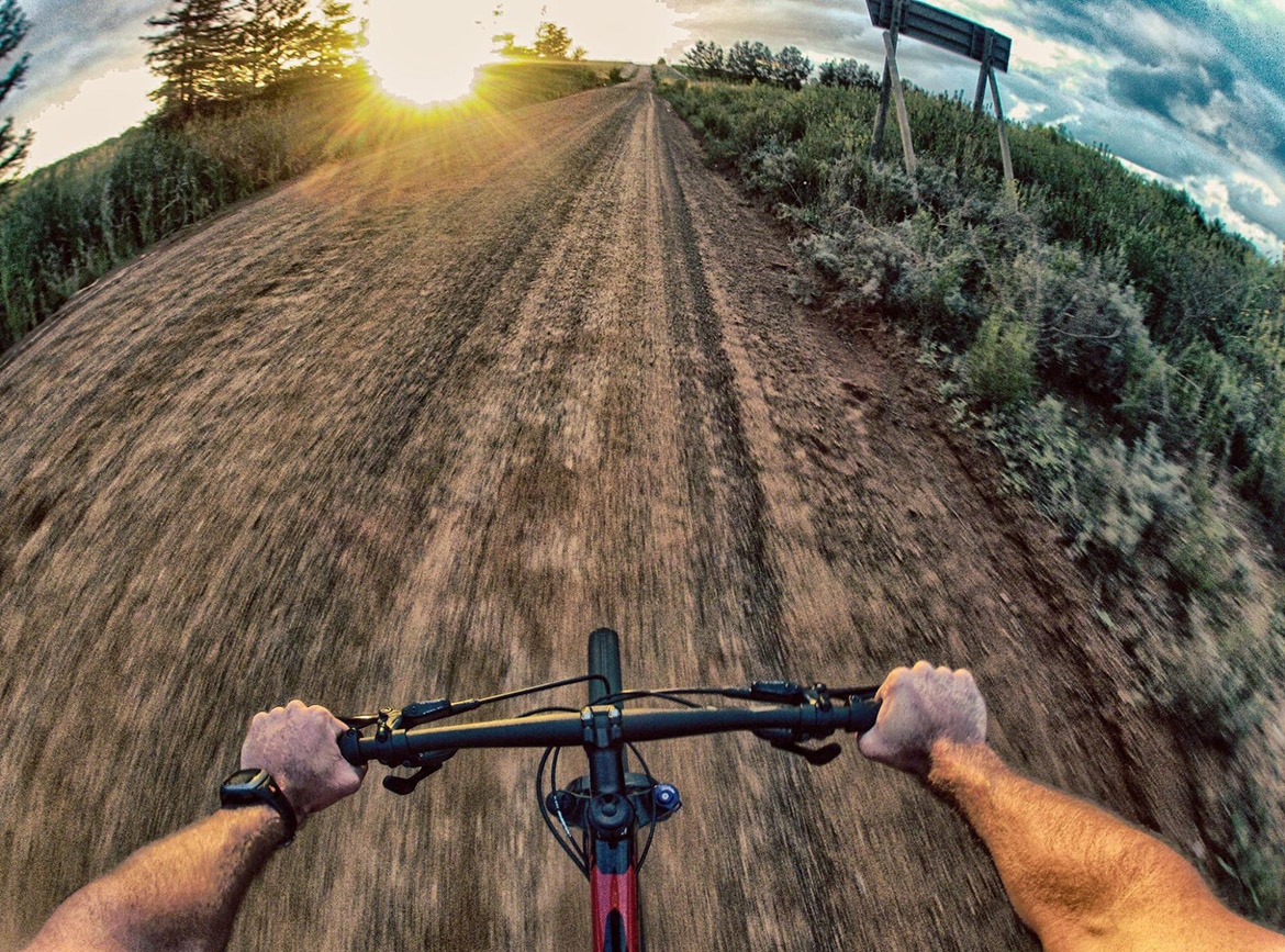 Handlebar Mount man grabbing handlebars on bike on dirt road in nature