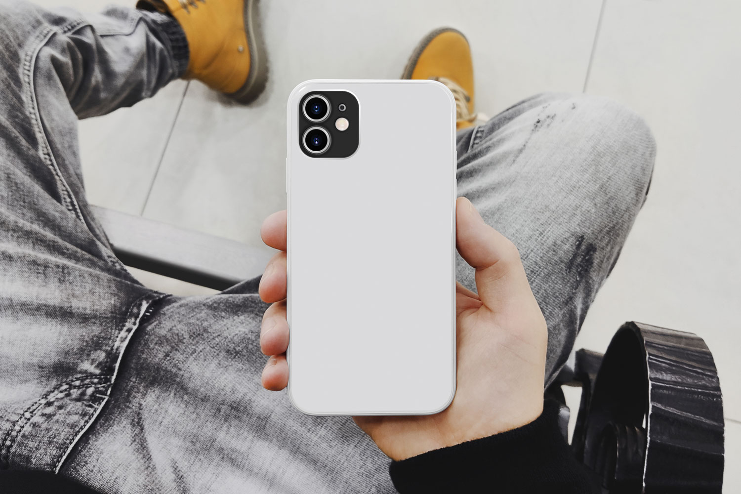 man holding iphone showing back of white case
