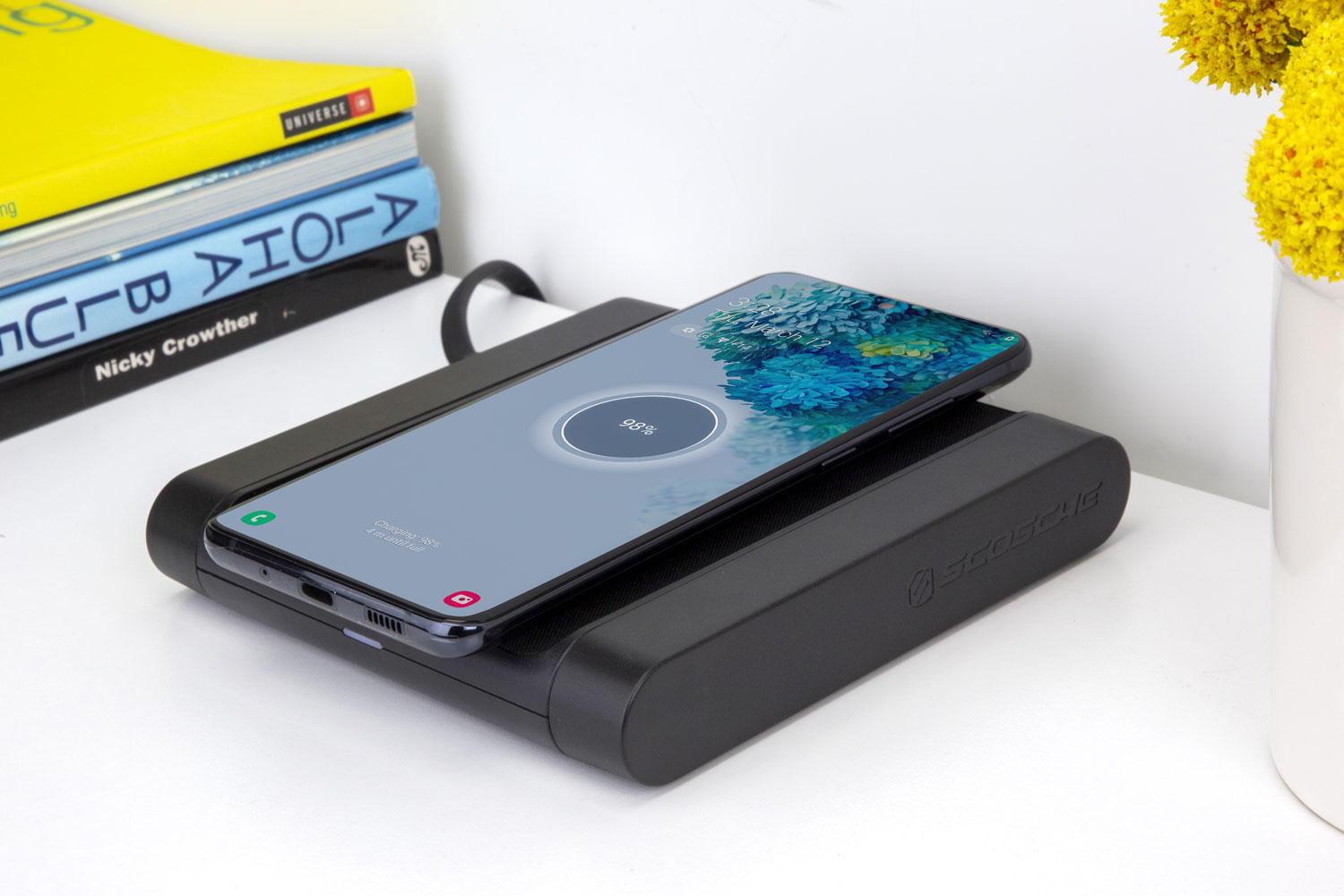 Samsung phone charging via Scosche wireless charging pad on tabletop