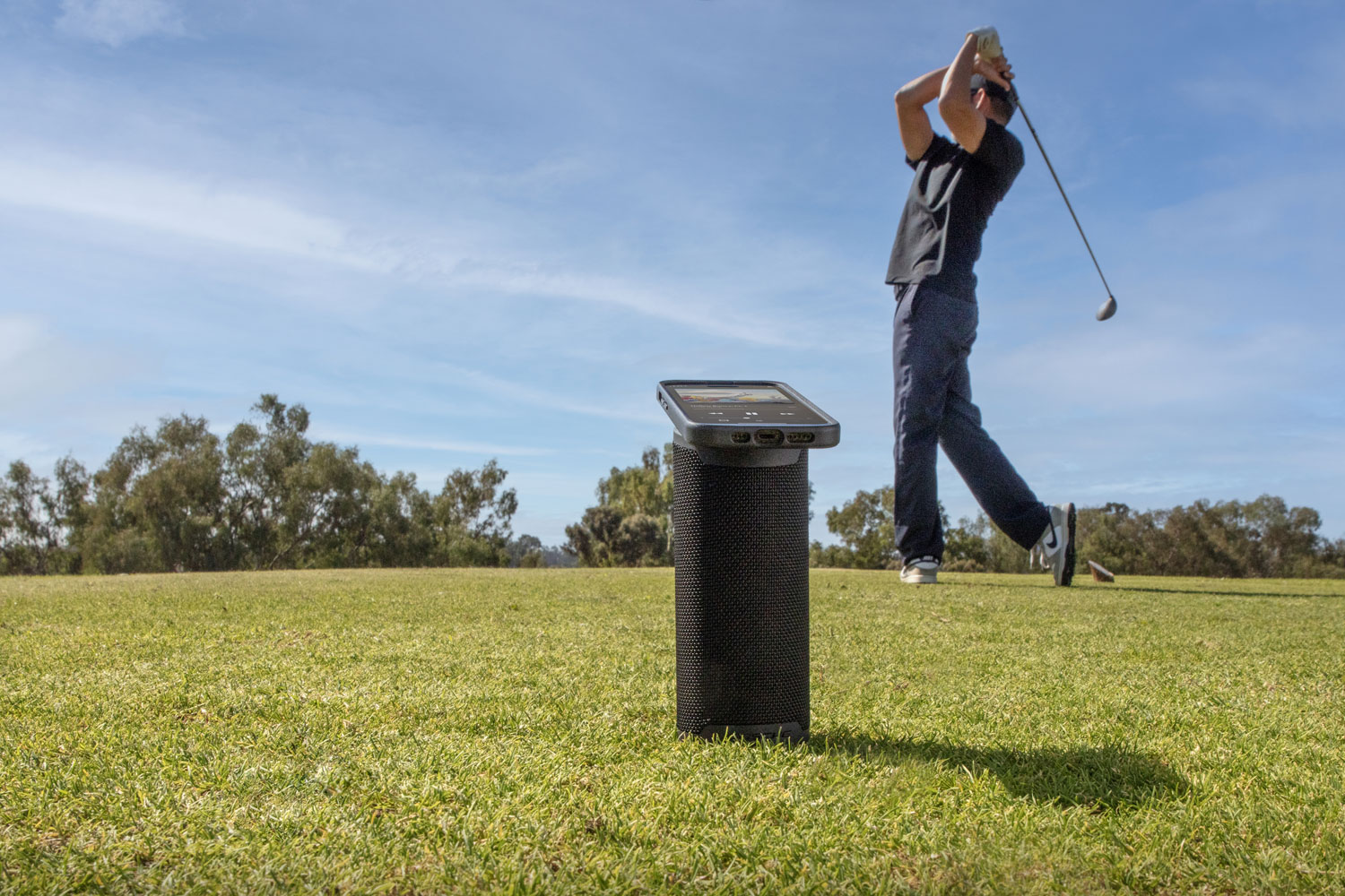 man golfing while listening to music via Scosche MagSage wireless speaker