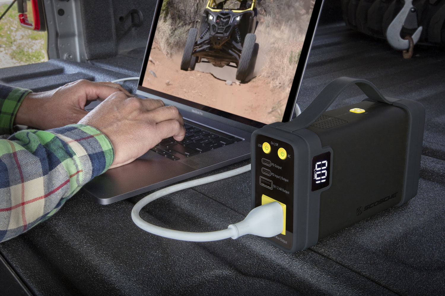 man using laptop while charging via portable power station