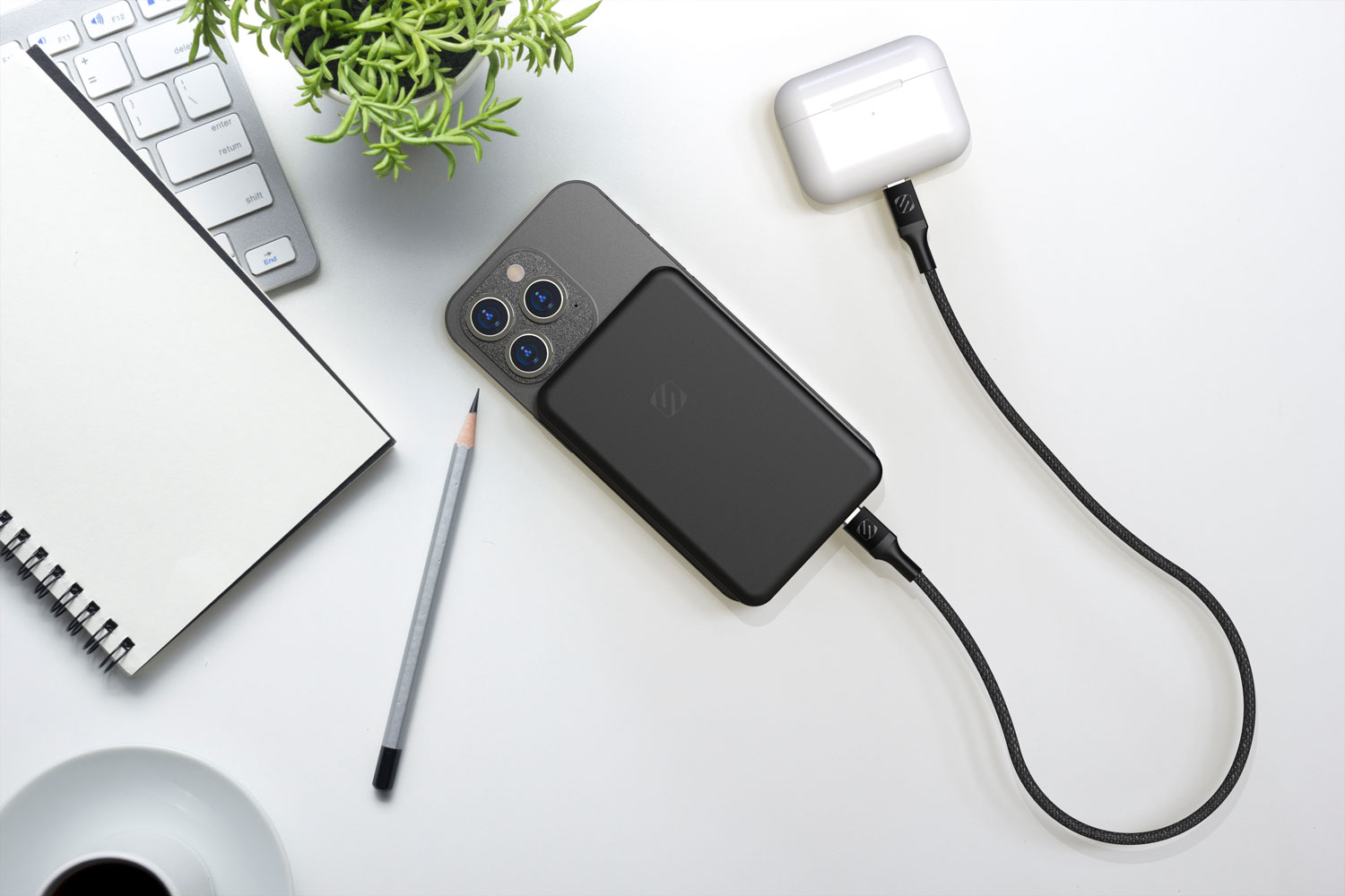 iphone charging on desk via Scosche MagSafe portable power bank with Airpods charging via cable