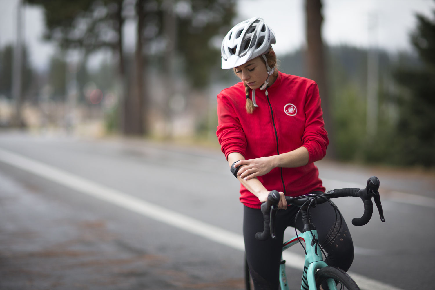 woman on bike checking armband heart rate monitor