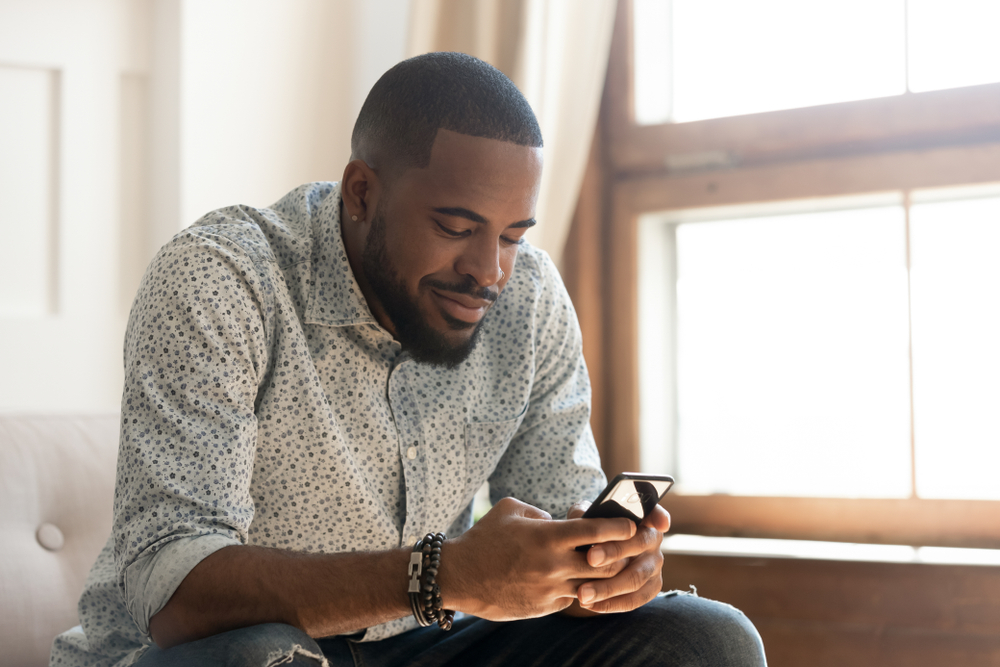 happy man using phone happy man using phone sitting on sofa
